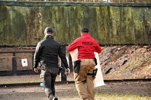 na zdjęciu widać dwóch instruktorów wyszkolenia strzeleckiego, którzy zmierzają w kierunku kulochwytu