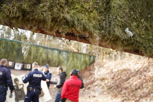 policjanci wraz z instruktorem idą w kierunku kulochwytu