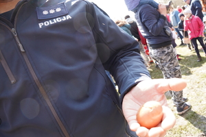 policjant trzyma w dłoni rozbite jajko