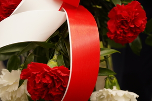 fragment wstążki koloru czerwonego w wiązance kwiatów w kolorze biało-czerwonym