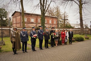 stojący w rzędzie policjanci, przedstawiciel wojska, straży pożarnej oraz lokalni samorządowcy