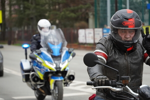 jadący drogą motocyklista, tuż za nim policjant na motorze