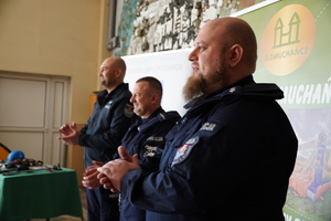 stojący obok siebie trzej policjanci