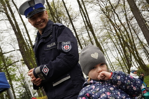 policjant drogówki uśmiecha się i  patrzy na dziecko