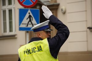 policjant drogówki w odblaskowej kamizelce kieruje ruchem