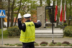 policjant drogówki kieruje ruchem, w tle pomnik narodowy