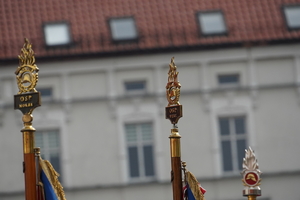 fragmenty sztandarów strażackich. W tle budynku na rynku