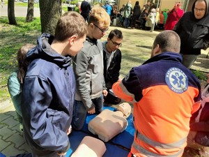 na zdjęciu widać ratownika medycznego, który szkoli uczestników pikniku z udzielania pierwszej pomocy
