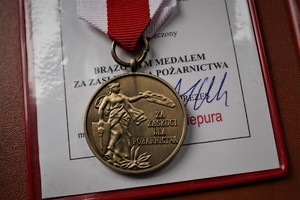 leżący na legitymacji medal