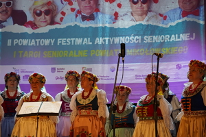 scena, na niej zespół taneczny, w tle plakat informacyjny dotyczący festiwalu