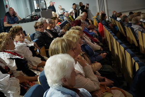 grupa seniorów siedzących na krzesłach sali widowiskowej w Łaziskach Górnych