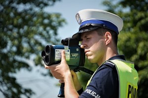 zdjęcie przedstawia policjanta drogówki z radarem