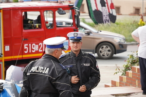 dwaj policjanci drogówki, za nimi wóz straży pożarnej