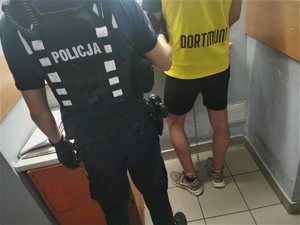 policjant z zatrzymanym mężczyzną podczas badania