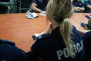 policjantka siedzi przy stole podczas służbowej odprawy