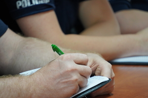 policjant wykonuje zapis w notatniku służbowym