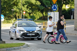 policyjny radiowóz zatrzymuje się by przepuścić pieszych na oznakowanym przejściu