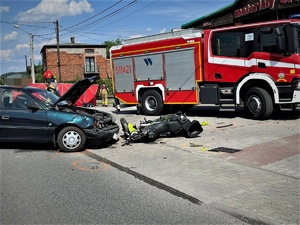 wypadek na drodze, rozbite pojazdy, za nimi wóz straży pożarnej