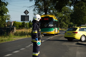 strażak kieruje ruchem, za nim autobus miejski