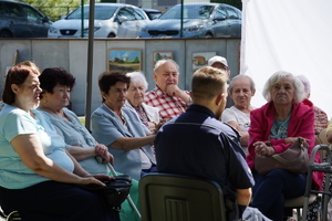 policjant, a wokół niego siedzą seniorzy