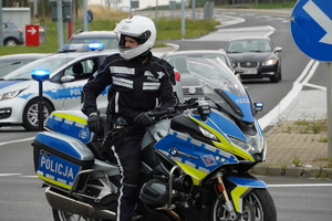 policjant ruchu drogowego na motocyklu, trwa zabezpieczenie trasy wyścigu