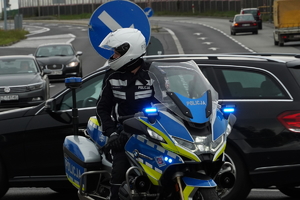 policjant ruchu drogowego na motocyklu, trwa zabezpieczenie trasy wyścigu, zdjęcie wykonane na skrzyżowaniu w Mikołowie