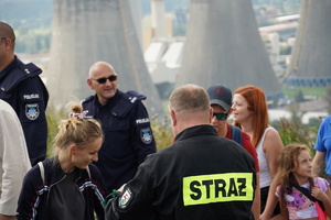 policjanci wśród innych uczestników imprezy w Łaziskach Górnych, w tle kominy elektrowni