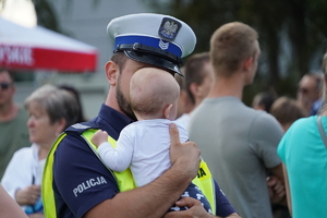 policjant drogówki trzyma na rękach malutką dziewczynkę