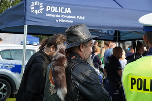 uczestnicy pikniku stoją przy niebieskim namiocie mikołowskiej Policji
