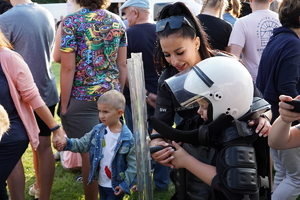 funkcjonariuszka służby więziennej pokazuje chłopcu wyposażenie formacji