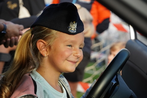 mała dziewczynka pozuje do zdjęcia w policyjnej czapce