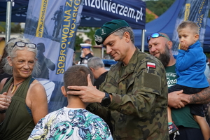 żołnierz wojskowego centrum rekrutacji maluje chłopcu twarz