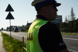 policjant drogówki w odblaskowej kamizelce stoi przy drodze numer 44