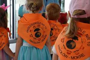 3-letnie przedszkolaki w chustach koloru pomarańczowego z logo przedszkola