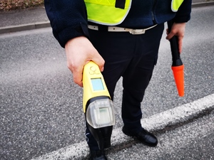 policjant drogówki trzyma w ręce urządzenie do pomiaru stanu trzeźwości