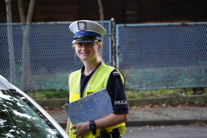 policjantka ruchu drogowego pozuje do zdjęcia na tle radiowozu