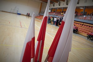 trzy flagi Polski stojące w rogu sali gimnastycznej