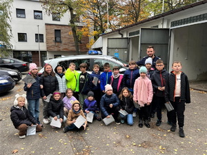 zbiorowe zdjęcie uczniów na parkingu przy komisariacie