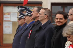 policjanci w mundurach wyjściowych stoją na płycie rynku obok przedstawicieli samorządu