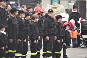 stojący w grupie na rynku strażacy - ochotnicy