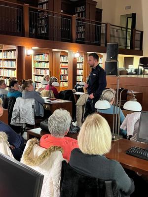 policjant podczas profilaktycznego spotkania w budynku biblioteki