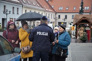 dzielnicowy w towarzystwie seniorów stoi na tynku w Mikołowie