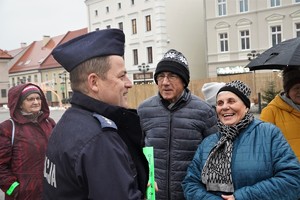 dzielnicowy aspirant sztabowy Maciej Dobrowolski rozmawia z grupą osób na rynku w Mikołowie