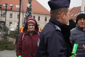 starsza kobieta, obok niej policjant