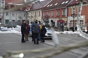 mikołowski rynek, grupa seniorów otacza dzielnicowego, w tle zabudowania