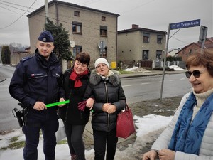 policjant pozuje do zdjęcia z seniorami z Wyr