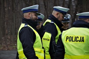 policjanci drogówki w odblaskowych kamizelkach podczas kontroli drogowej