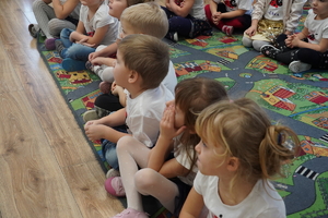 siedzące na dywanie przedszkolaki