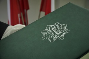 zielona teczka, na której jest logo z napisem Policja Mikołów