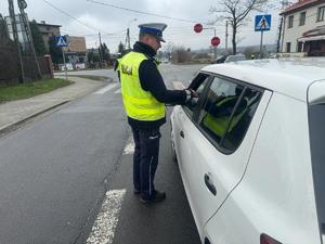 zdjęcie przedstawia policjanta i samochód